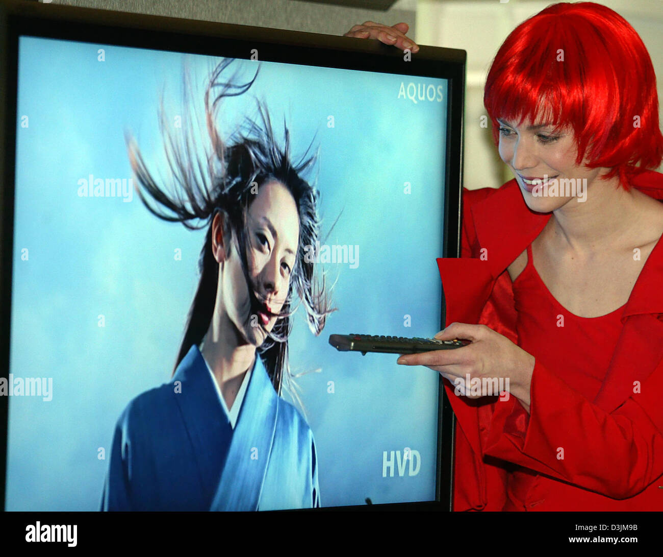 (dpa) - 'Miss IFA' activates with a remote control a flat screen in Berlin, Germany, 16 February 2005. During a press conference for the IFA (Internationale Funkausstellung/international radio exhibition) numerous novelties were announced to representatives of the press. The world's largest fair for consumer electronics will take place in Berlin between 2 and 7 September 2005. Stock Photo