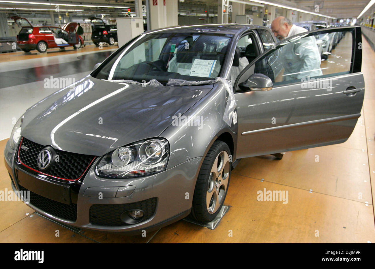 (dpa) - An employee (R) of Volkswagen (VW) conducts the final ...