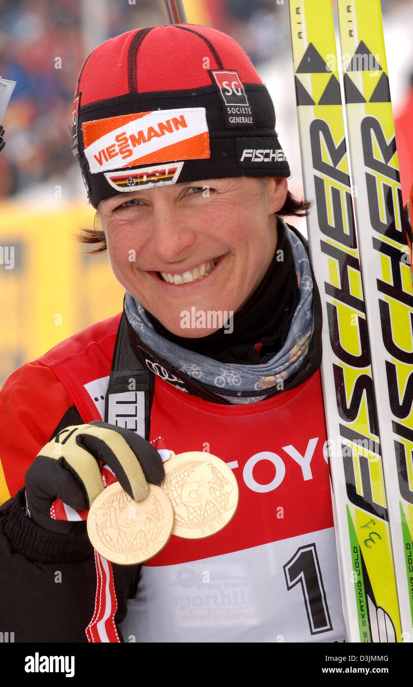 (dpa) German biathlete Uschi Disl smiles as she presents he two gold