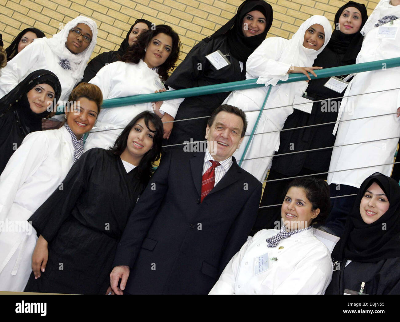 (dpa) - German Chancellor Gerhard Schroeder (C, front) smiles as he poses with a group of young women from Kuwait for a group picture during his visit at the Institute for Professional Education where he informed himself about the training and education of young women from Kuwait in Kuwait-City, Kuwait, 01 March 2005. Schroeder is on a week-long tour of seven Arab countries aimed a Stock Photo