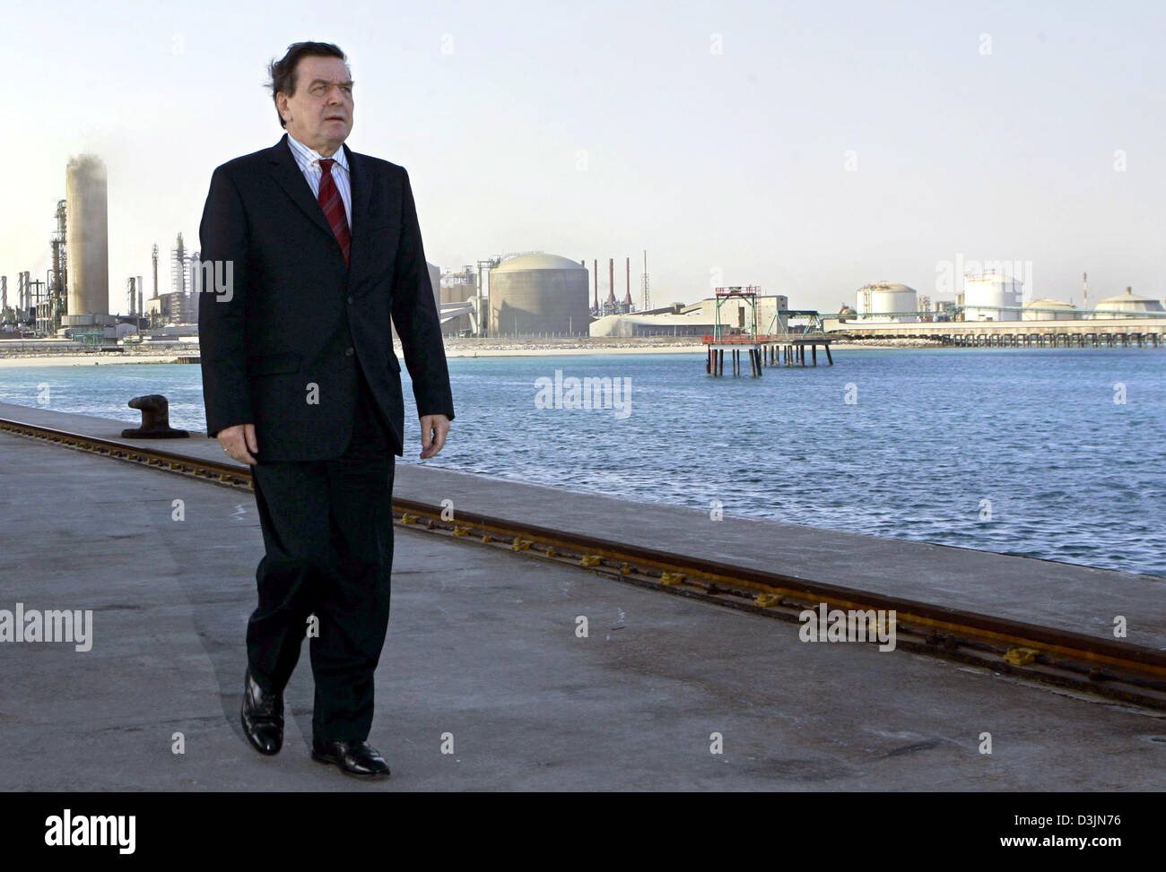 (dpa) - German Chancellor Gerhard Schroeder walks along a pier during his visit at a production plant for fertilizers which was built by the German company Uhde in Mesaieed, Qatar, Tuesday, 01 March 2005. Schroeder is on a week-long tour of seven Arab countries aimed at boosting Germany's trade and political relations in the Gulf region. Stock Photo