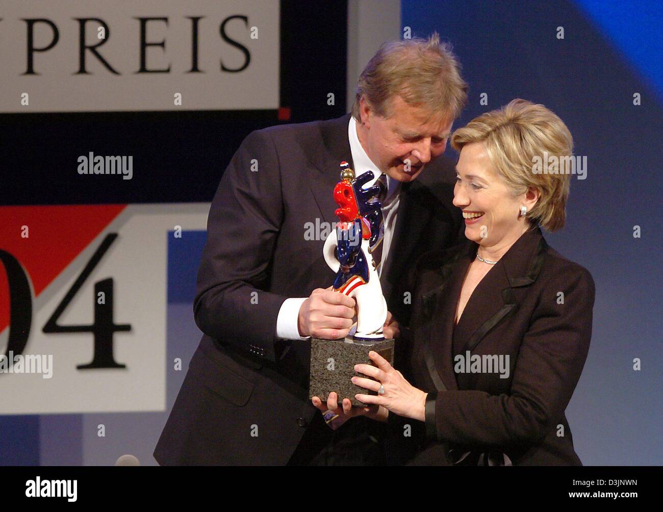 (dpa) - US Senator Hillary Clinton (R) smiles as she receives the German Media Prize 2004 from Karlheinz Koegel, Head of Media Control and founder of of the Media Prize, in Baden-Baden, Germany, 13 February 2005. Clinton was awarded the prize for her exemplary engagement advancing the role of women in the world of politics, society and media. Stock Photo