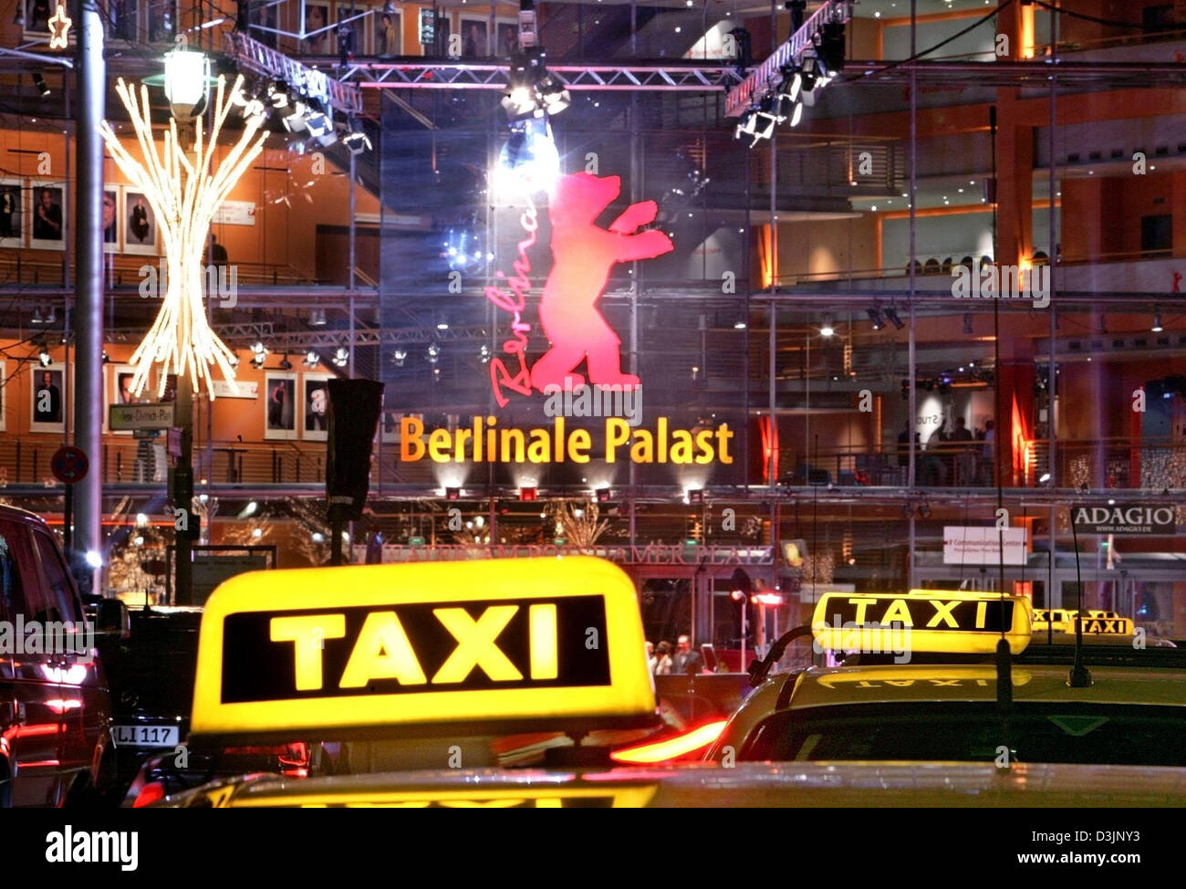 (dpa) - Illuminated yellow cap signs of waiting taxis queue in front of the Berlinale-Palast, one of the main venues of the 55th Berlinale Filmfestival, in Berlin, 17 February 2005.  keywords: Arts-Culture-Entertainment, ACE, Cinema, yellow, signs, berlinale, logo, filmfestival, film festival, cab, taxi, GERMANY:DEU, symbolic, exterior, night scene Stock Photo