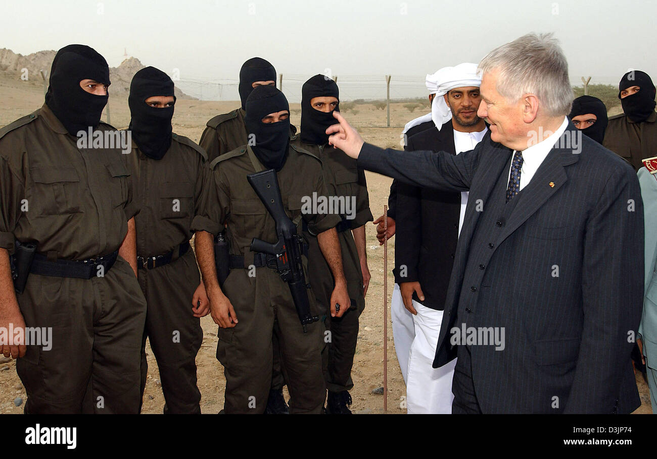 Their faces hidden under ski masks stand Iraqi policemen in front of