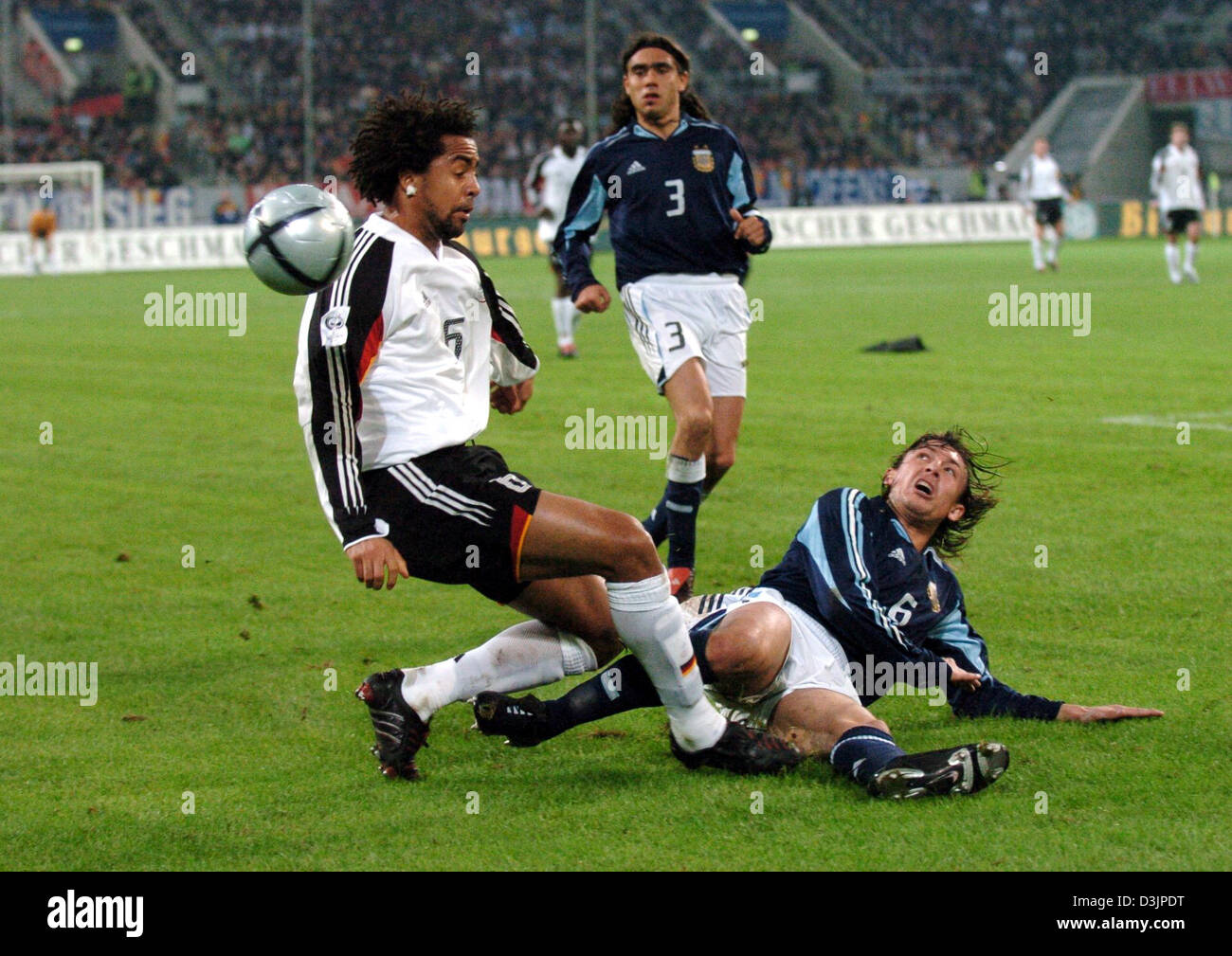 (dpa) - Germany's Patrick Owomoyela (L) struggles for the ball with Argentina's Gabriel Heinze (R) while Heinze's teammate Juan Pablo Sorin looks on during the international friendly between Germany and Argentina at the LTU arean in Duesseldorf, Germany, 09 February 2005. Stock Photo