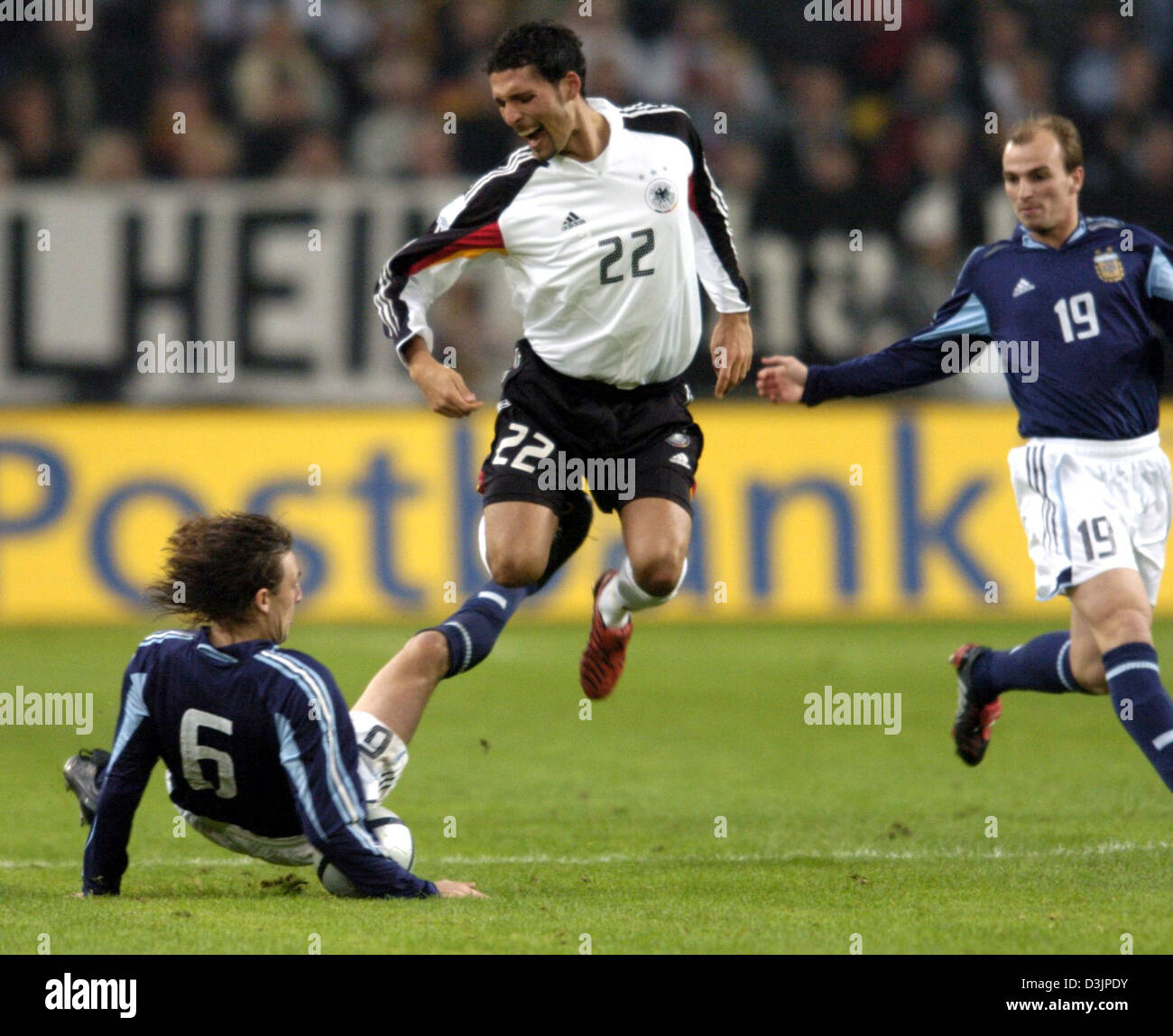 (dpa) - Argentina's Gabriel Heinze (L) fouls Germany's Kevin Kuranyi (C), while Heinze's teammate Esteban Cambiasso looks on during the international friendly between Germany and Argentina at the LTU arean in Duesseldorf, Germany, 09 February 2005. Stock Photo
