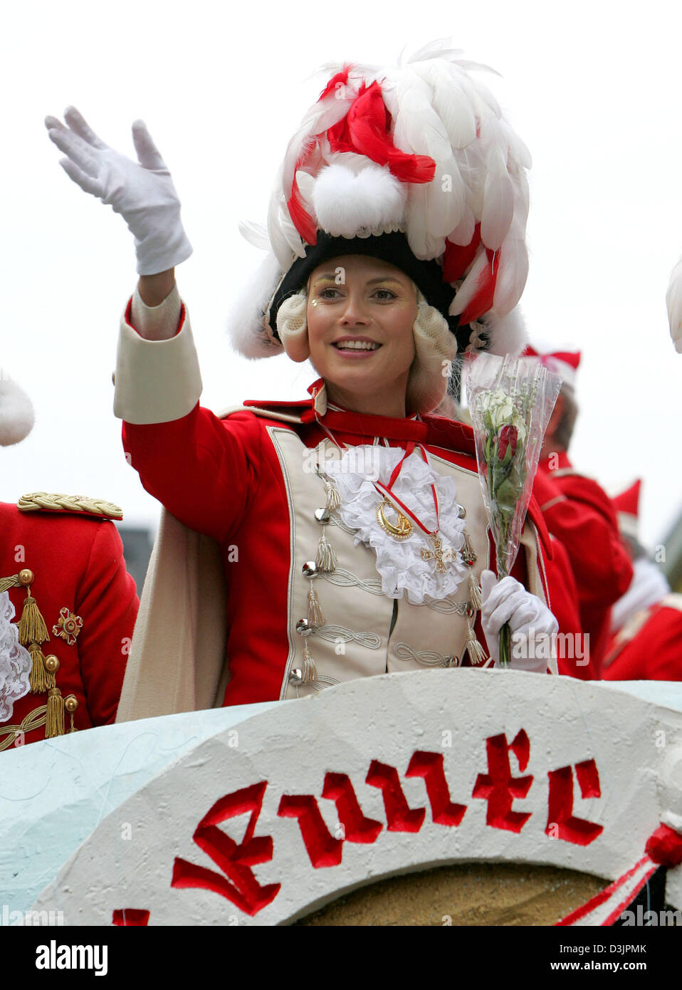 dpa) - German top model Heidi Klum smiles and waves her hand as she stands  on a trailer of the 'Rote Funken' (red sparks) carnival association during  the Carnival Monday procession in