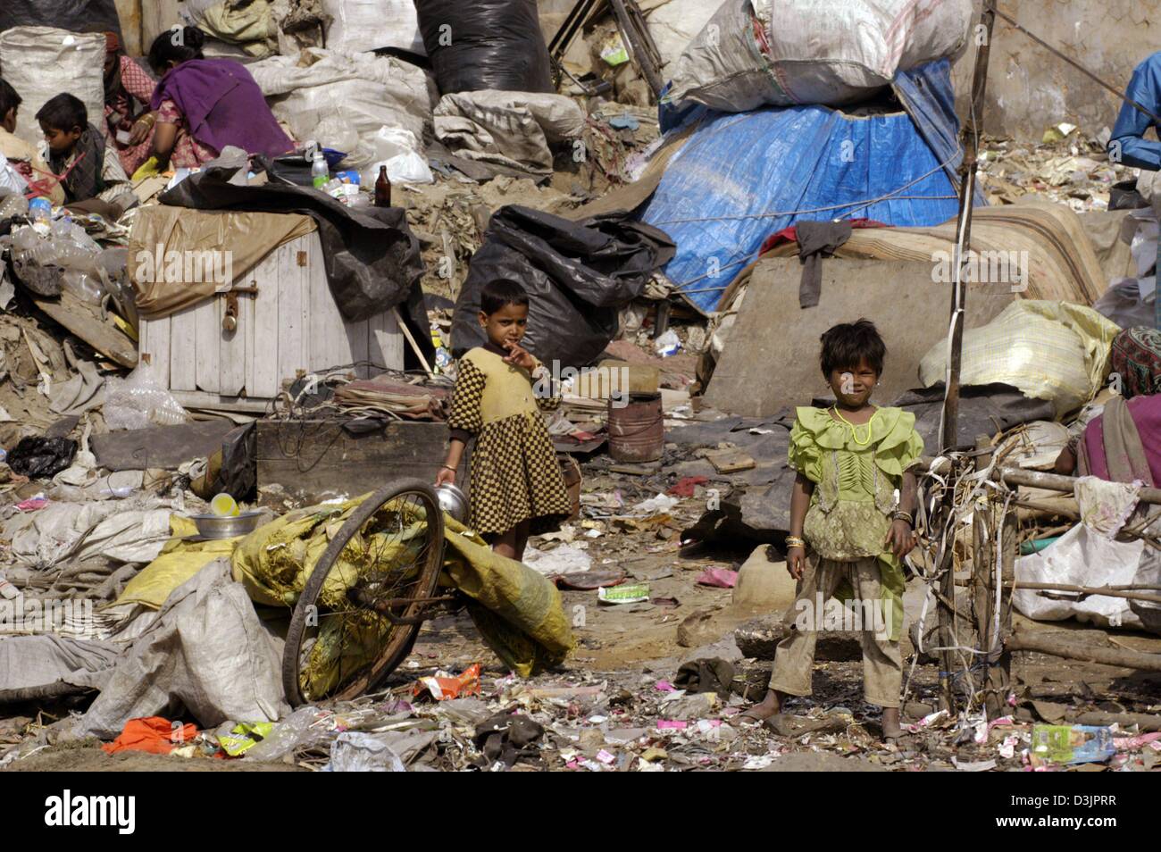 (dpa) - Children scavenge for any usable items through a mountain of waste and rubbish on the outskirts of metropolitan Delhi, India, 02 February 2005. While modern high-rises are being built in the business districts of India's inner cities, countless Indians still live in poverty in a country with more than one billion people. Despite the legal abolition of the caste system, the  Stock Photo