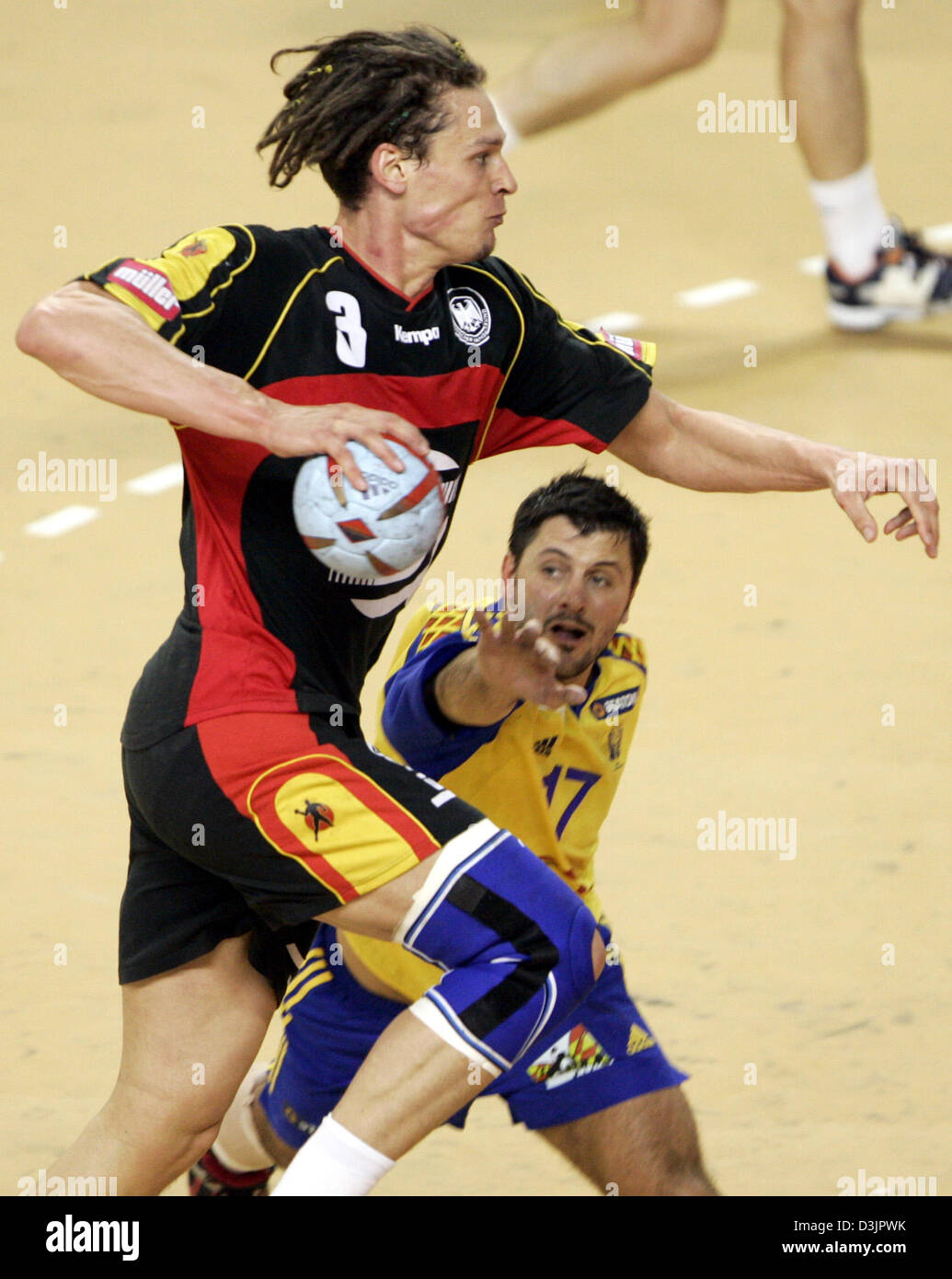 dpa) - German handball player Frank von Behren (front) jumps up to throw  the ball asserting himself against Swedish player Ljubomir Vranjes in the  final game of the main round between Sweden