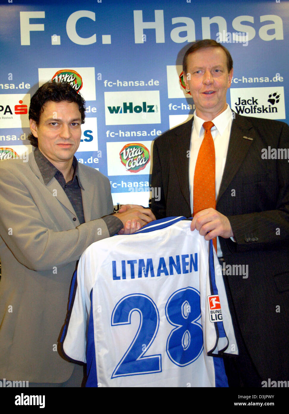 dpa) - Finnish national player Jari Litmanen (L) receives his jersey as the  new player of soccer club Hansa Rostock, which is in the danger of  relegation, by Hansa Chairman Manfred Wimmer