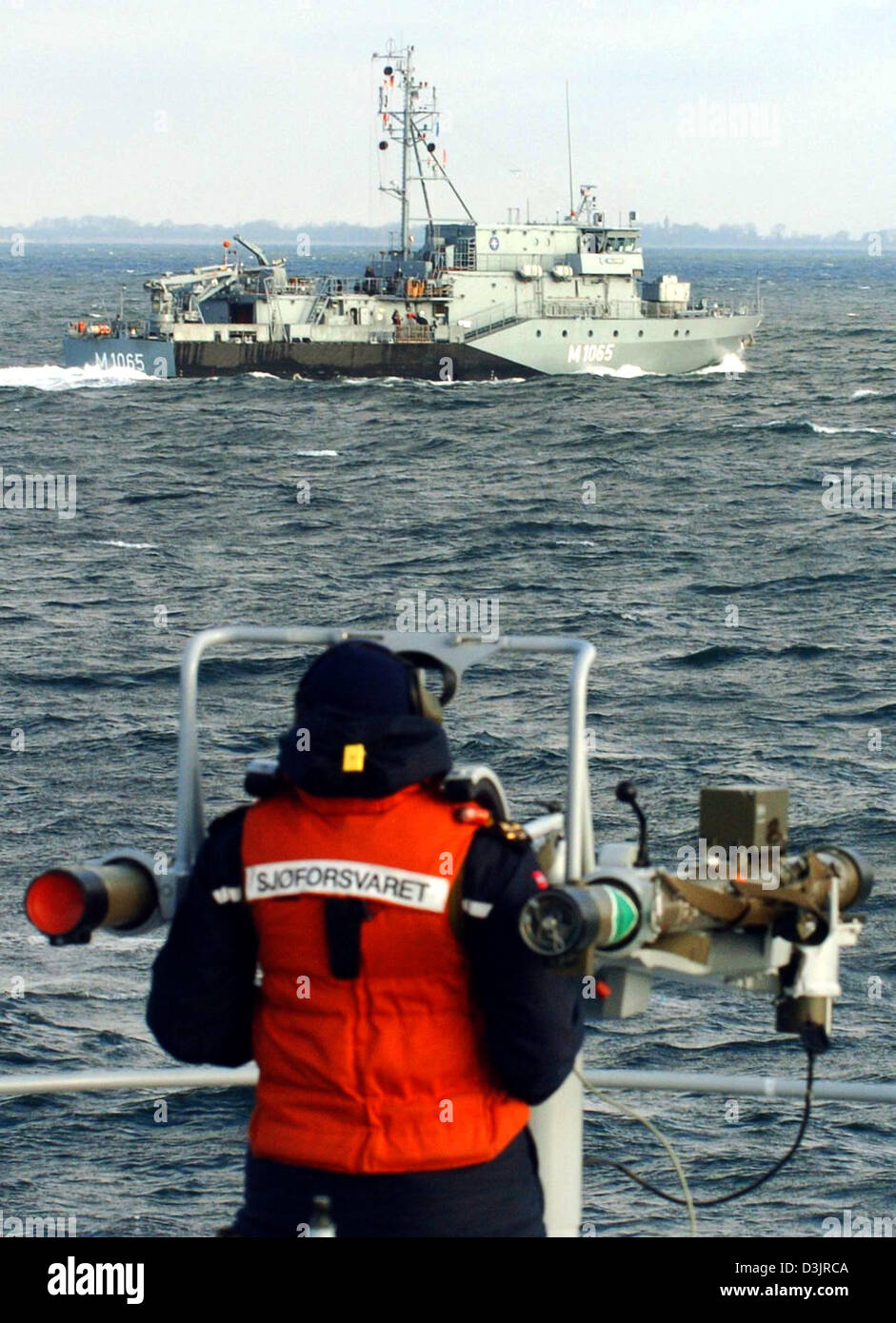 (dpa) - A navy sailor of the Norwegian minesweeper 'HNoMS Alta' practice the use with an anitaircraft gun of the type 'Mistral' while the German navy ship 'Dillingen' passes by on the Baltic Sea near Neustadt, Germany on Wednesday 26 January 2005. Six vessels of the Standing Nato Response Force Mine Counter Measure Group 1 from five nato member states participate in fire fighting,  Stock Photo
