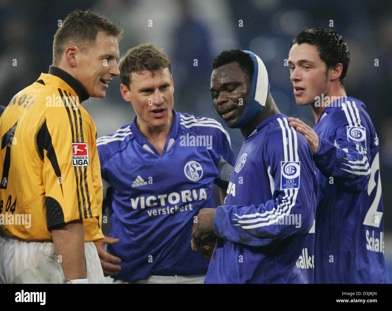 (dpa) - German Premier League (Bundesliga) match FC Schalke 04 vs. SV Werder Bremen at the 'AufSchalke' stadium on 22 January 2005. Schalke's goalkeeper Frank Rost, Ebbe Sand and Christian Pander (l to r) thank goalscorer Gerald Asamoah (second right), who had to play with a head bandage after an injury during the first half. Schalke won the match 2:1. Stock Photo