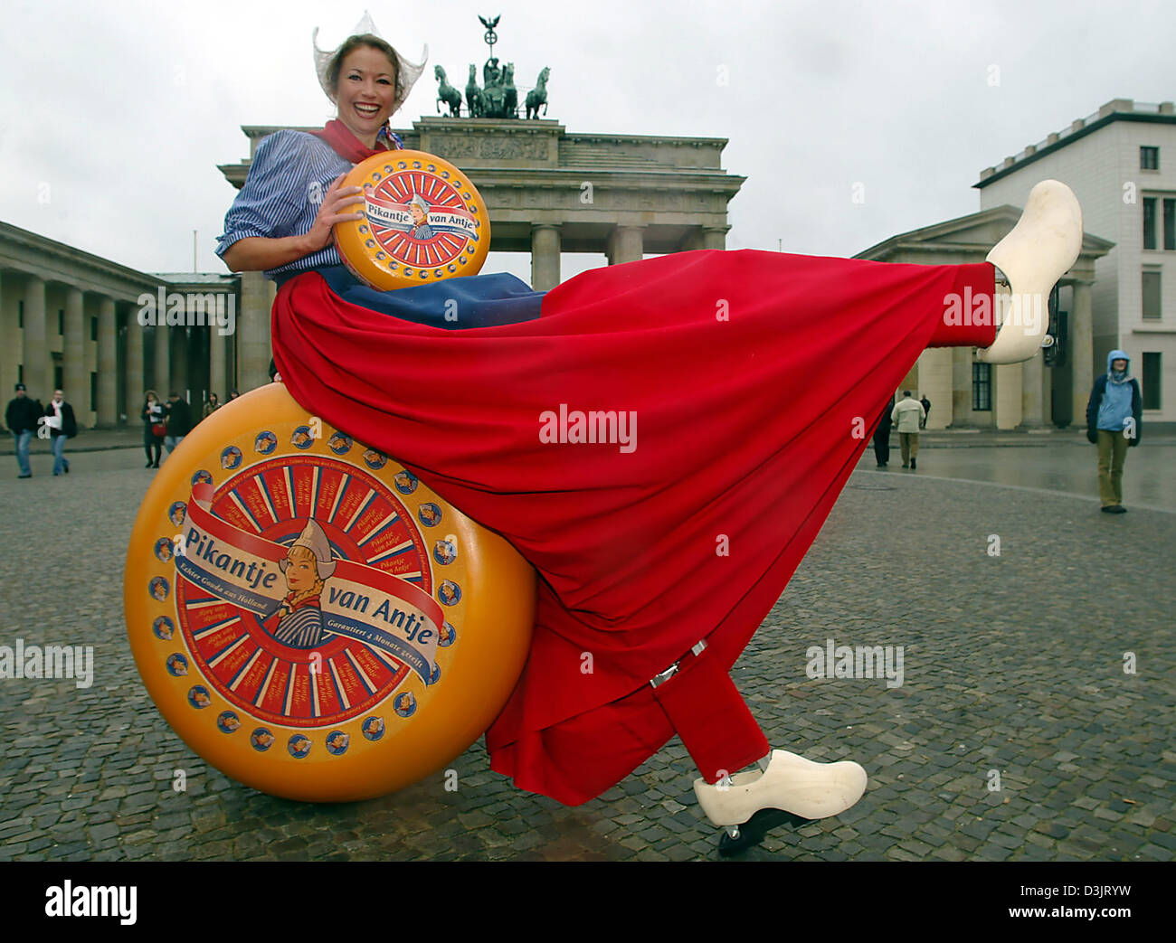 (dpa) - Standing almost 2.30 metres tall from her wooden shoes up to her pointy hat, Meisje Antje from the Netherlands sits on a large cheese in front of the Brandenburg Gate just in time for the 70th International Green Week exhibition in Berlin, Germany, 19 January 2005. For the start of the International Exhibition for the Food Industry, Agriculture and Horticulture, Madeleen Dr Stock Photo
