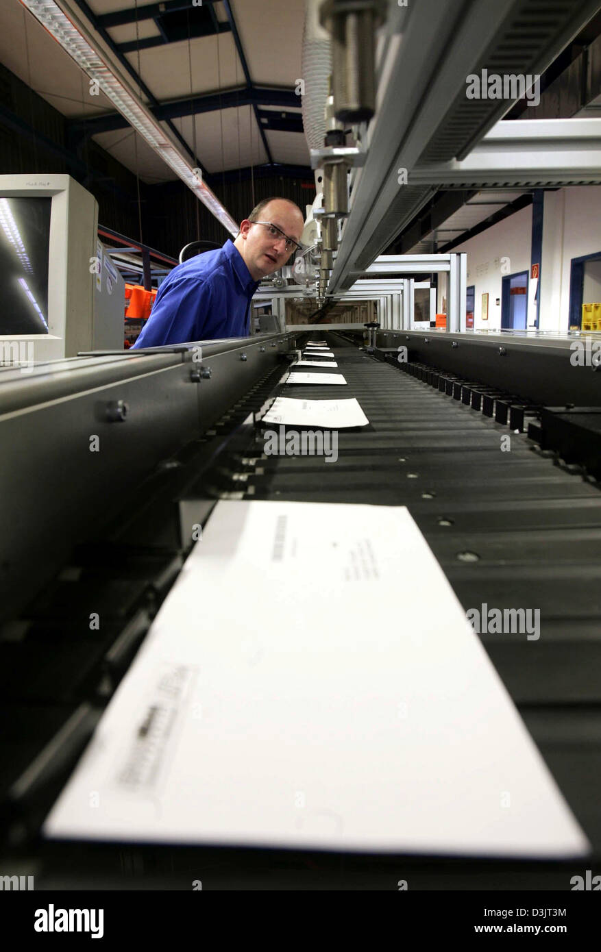 (dpa) - An employee of private German postal service MaxiMail observes a machine that automatically sorts letters in Darmstadt, Germany, 13 January 2005. About 50,000 to 80,000 letters are handled by MaxiMail in Darmstadt every day. Stock Photo