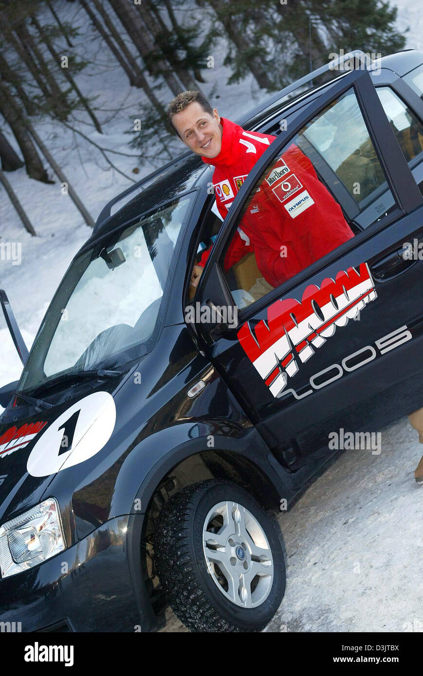 (dpa) - Seven time Formula 1 champion Michael Schumacher (team Ferrari) smiles as he stands next to a car with the word 'Wrooom' written on it shortly after arriving in the ski resort of Madonna di Campiglio, Italy, 11 January 2005. The Ferrari team got together for its traditional ski vacation under the motto 'Wrooom' in the Italian Alps. (ITALY OUT) Stock Photo