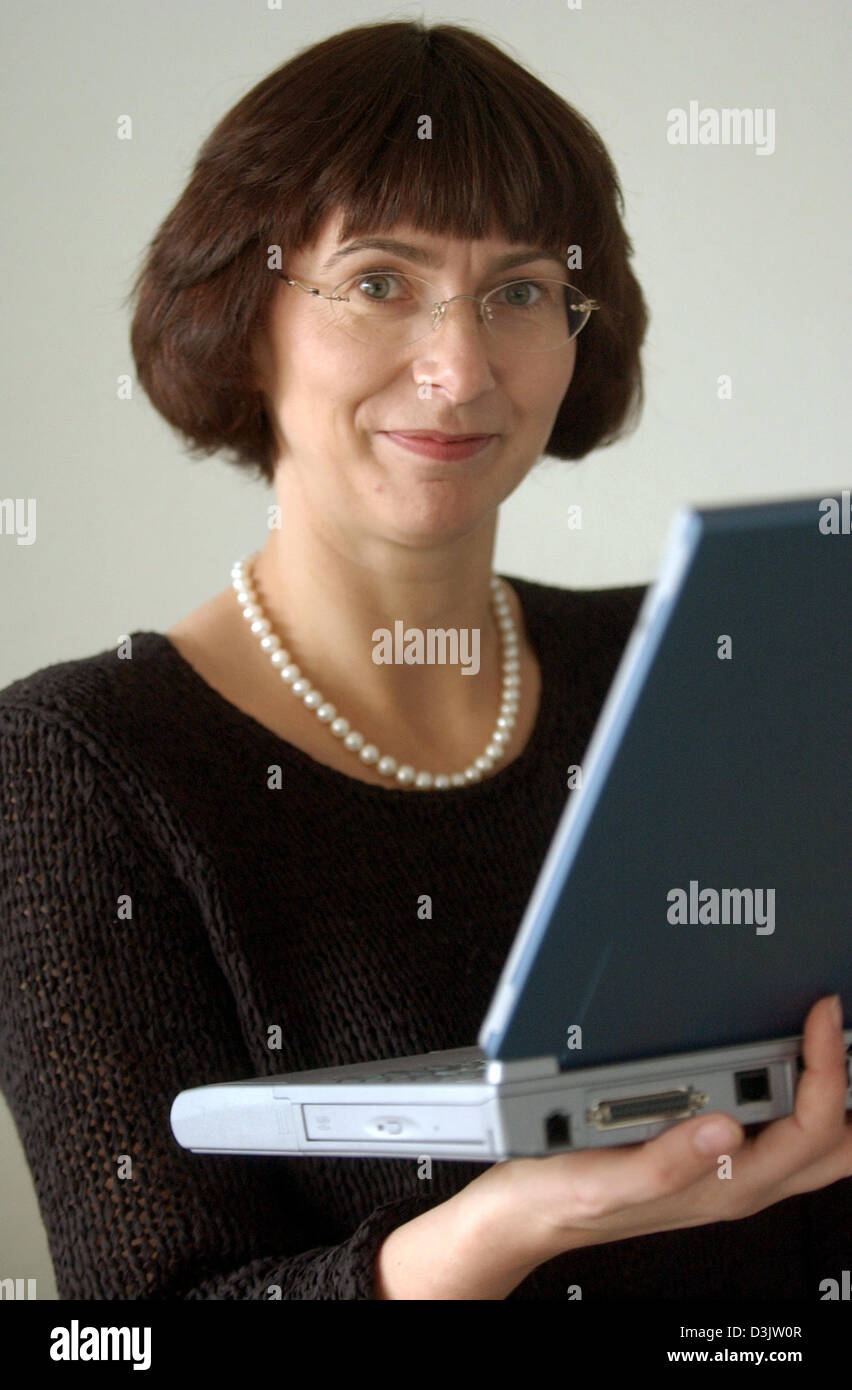 (dpa) - Maja Oelschlaegel, Anglist and Germanist smiles as she stands with a labtop in her hands in Dresden, Germany, 28 December 2005. Oelschlaegel has been the head mistress of the German International School in Silicon Valley, California, since August last year. The school is a pilot project which enables US pupils to graduate with a multilingual Abitur (German school leaving ex Stock Photo
