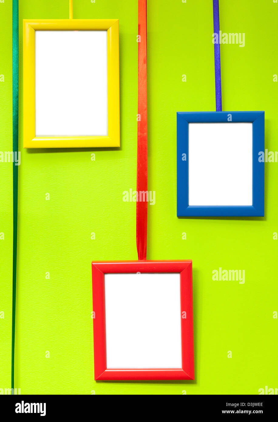 Colorful empty wooden frames on green wall Stock Photo