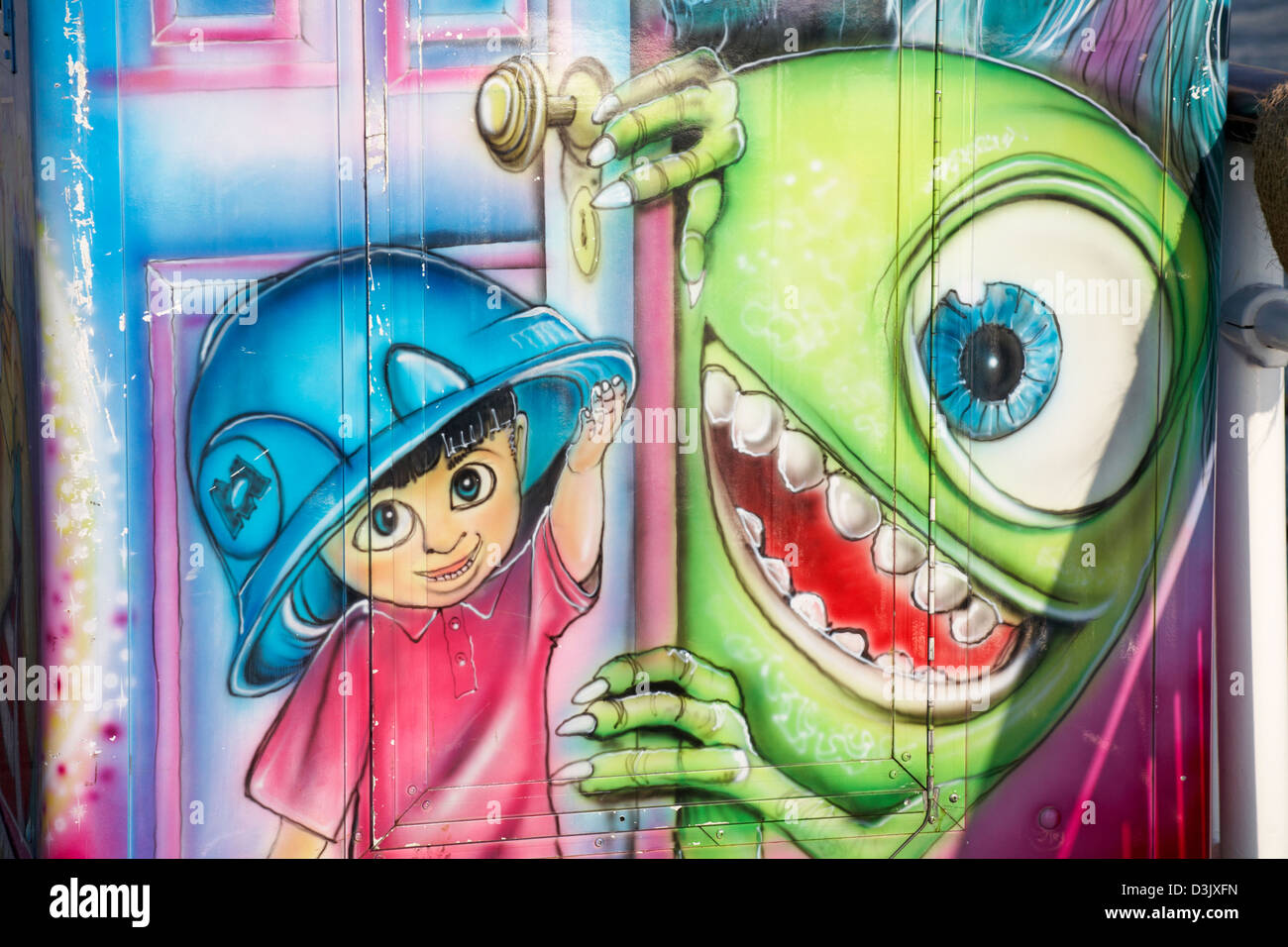 detail one eyed green monster and young boy wearing hard hat on booth on Bournemouth Pier in February Stock Photo