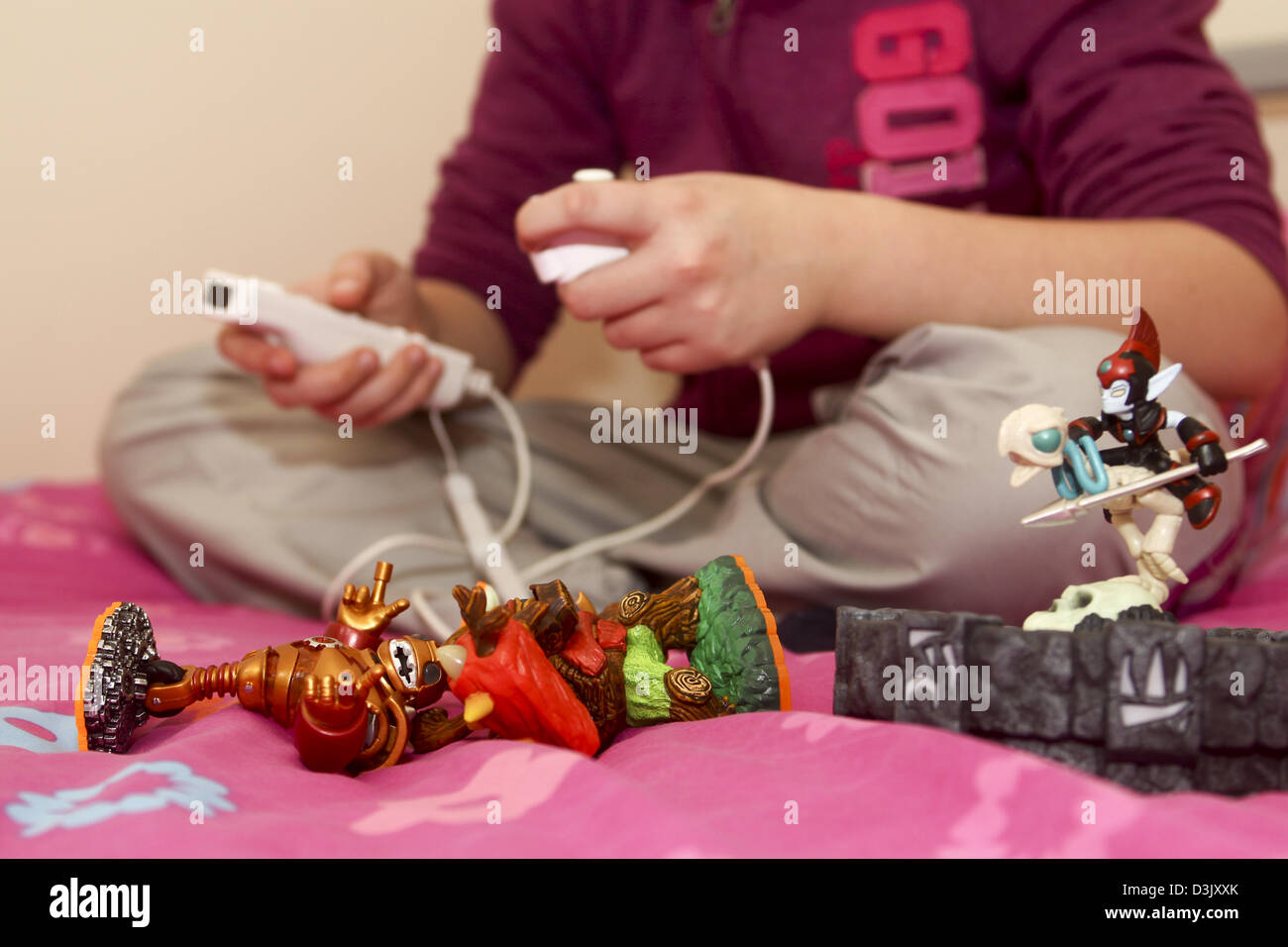 Young girl playing Skylanders video game on Nintendo Wii using portal and character figures Stock Photo