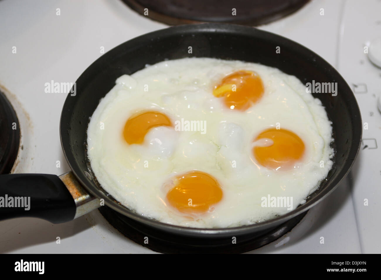 4 four fried egg yolks in frying pan Stock Photo - Alamy