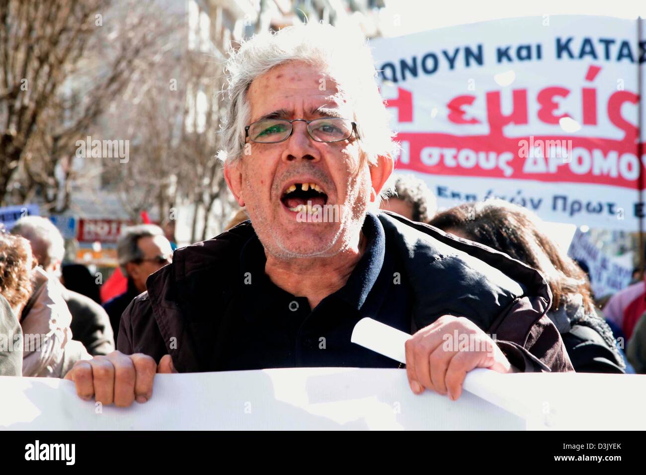Thessaloniki, Greece. 20th February 2013. A demonstrator holding a banner while shouting during a general strike on 20/02/2013 in Thessaloniki, Greece. The strike was called by the trade union confederations of GSEE and ADEDY. Protesters were demonstrating against the austerity measures in Greece which has seen taxes increased and wages, pensions and public spending cut.  Credit:  Art of Focus / Alamy Live News Stock Photo