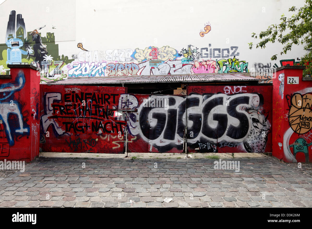 Berlin, Germany, graffiti sprayed with fire wall and metal gate at the street line Stock Photo