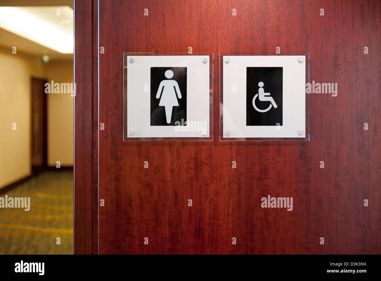 female and disabled toilet facility signs in hotel corridor Stock Photo
