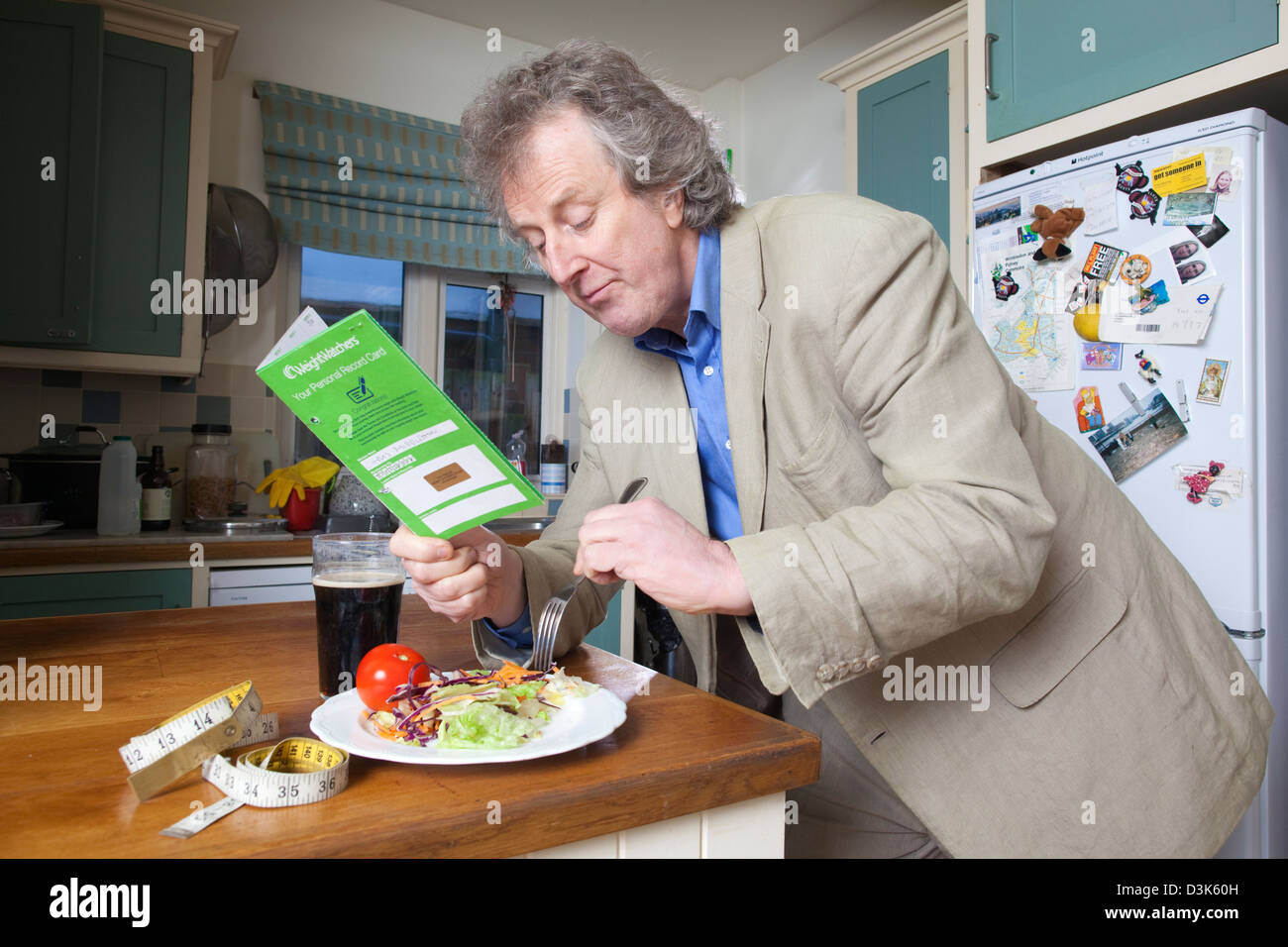 Middle aged man following his Weight Watchers personal record card requirements for his diet. Stock Photo