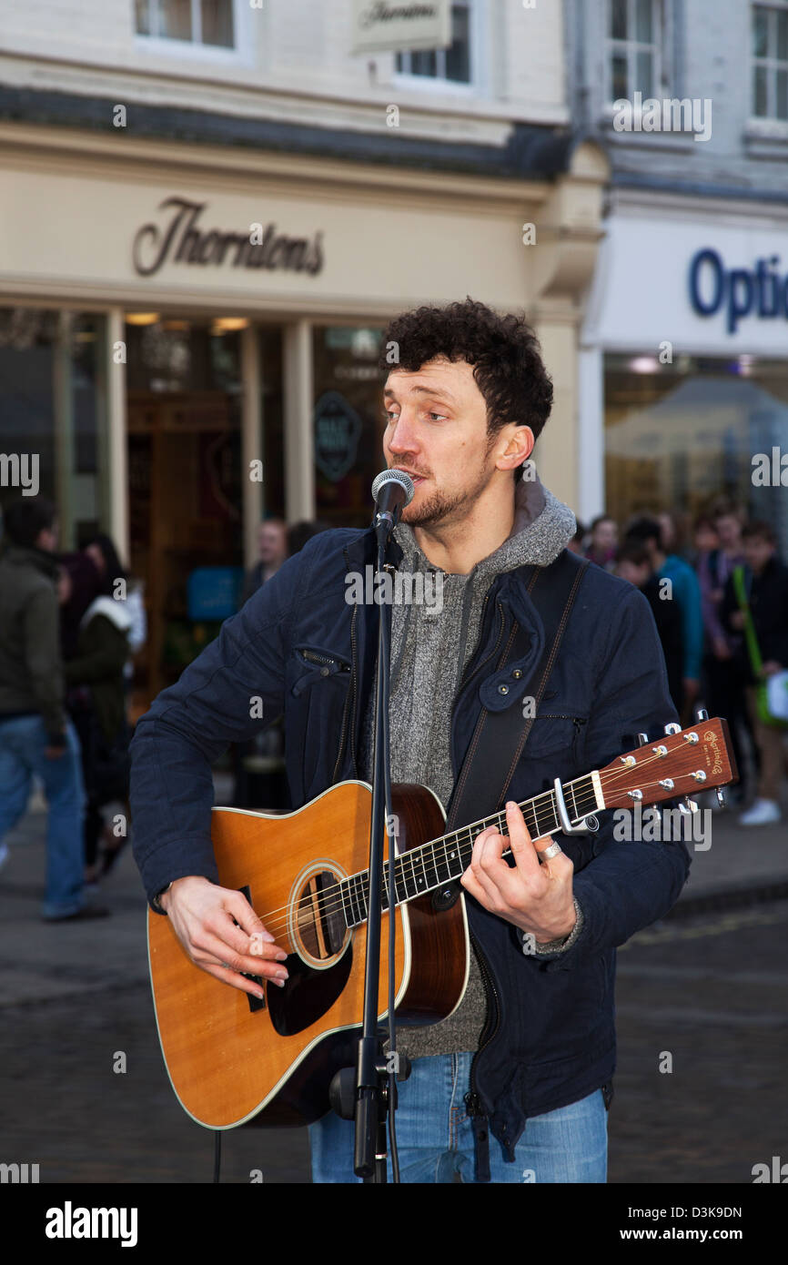 Licenced Buskers  Neil Ryan a musician singing into microphone, busking in the centre of York, Yorkshire, UK Stock Photo