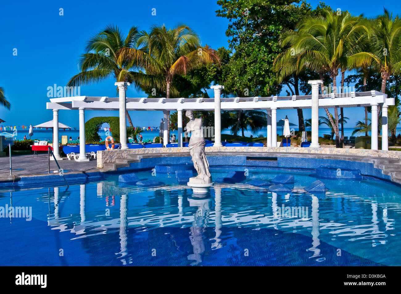 Negril JamaicaSwimming pool with bright reflections and classical statue at Hotel Riu Palace Tropical Bay all-inclusive resort, Stock Photo