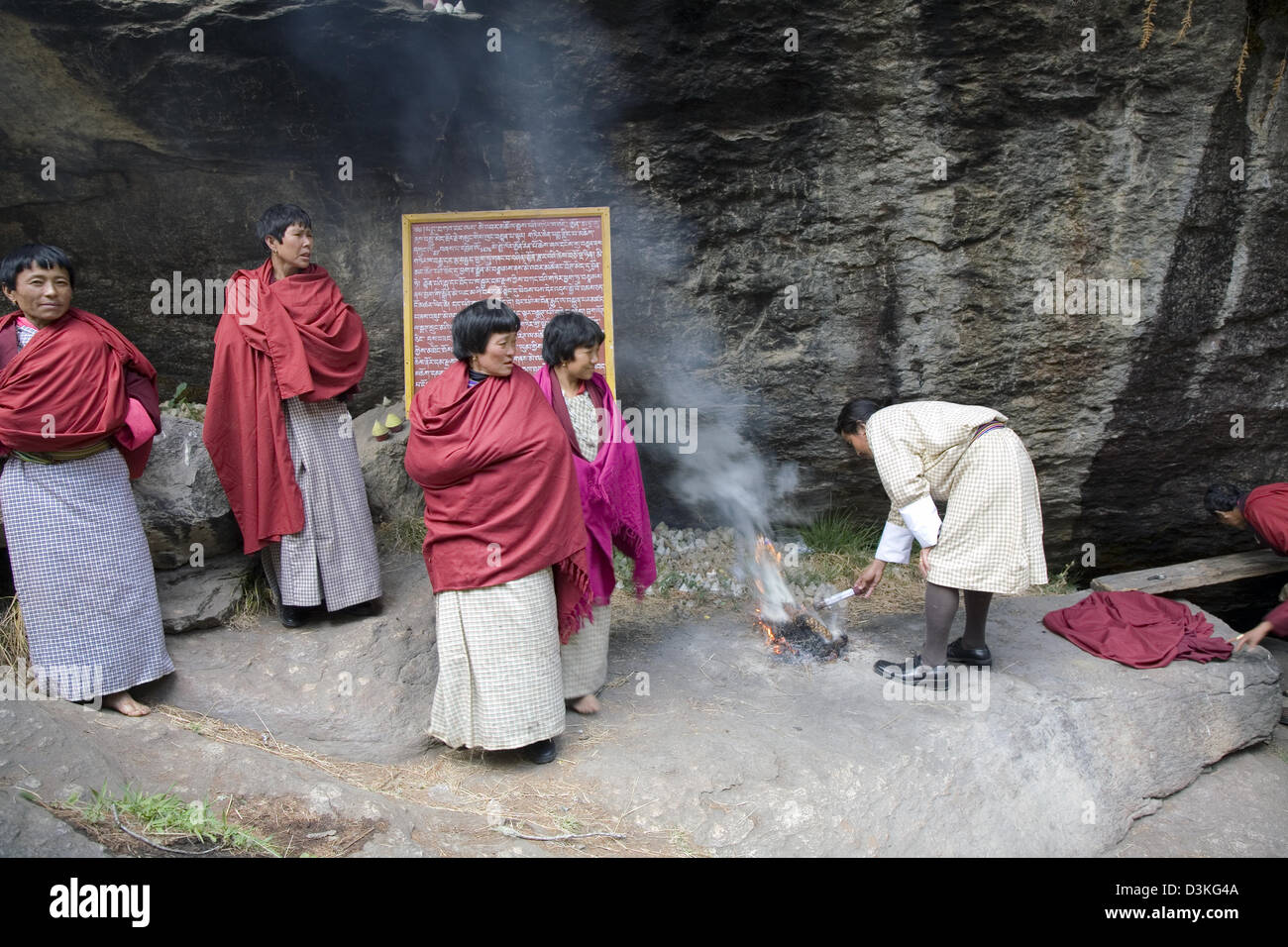 Worshippers place offerings on an altar at Membartsho, a sacred Buddhist site near Jakar, Bhutan, Asia Stock Photo