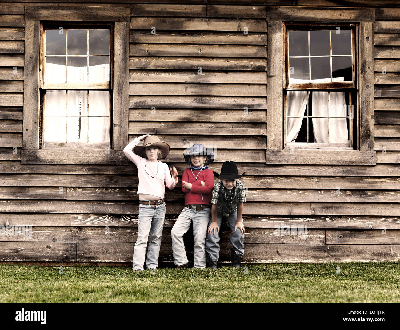 Triplets in cowboy hats on ranch in Montana, USA Stock Photo