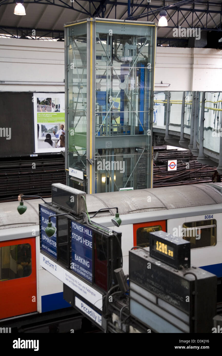 Lift to take passengers to platform, tube train, & destination sign, on the London Underground / metro at Earls Court station UK Stock Photo