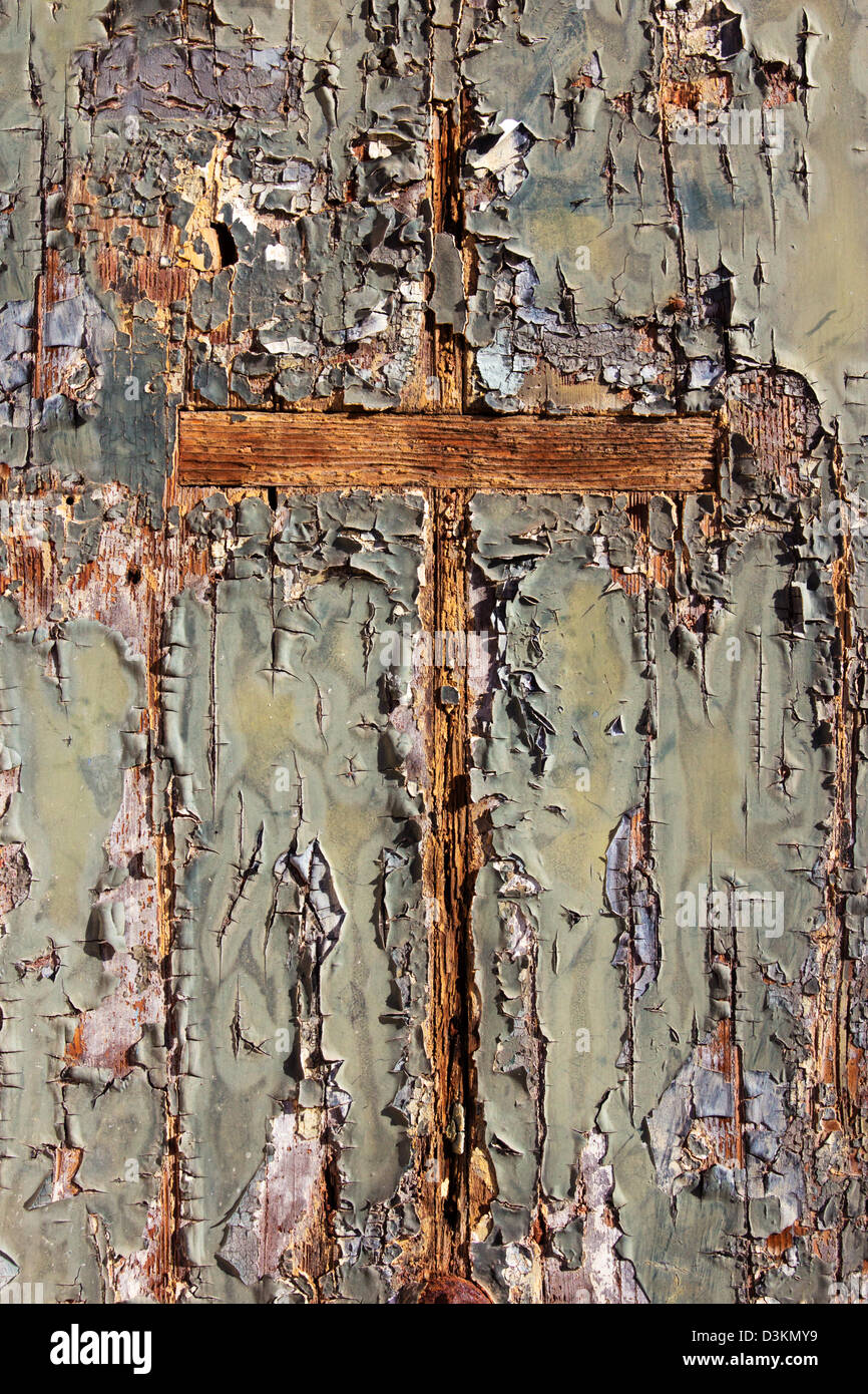 Wooden cross in a weathered door. Stock Photo