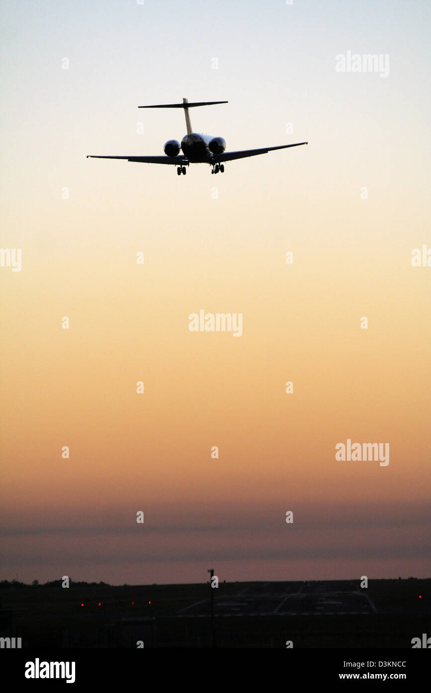 Airplane landing on Darwin Int'l airport (Australia) after sunset. Stock Photo