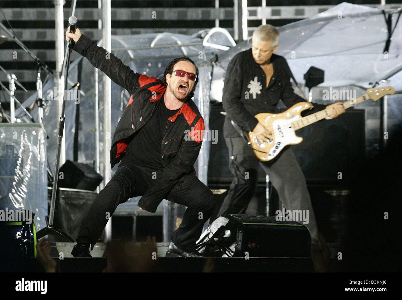 (dpa) - Bono (L), lead singer of the Irish pop band U2 performs on stage at the Olympiastadium in Munich, Germany, 03 August 2005. U2 concluded their tour through Germany with the concert in the Bavarian capital, promoting their album 'Vertigo'. They previously performed in Gelsenkirchen and Berlin. The more than 190,000 tickets of U2's Vertigo tour were sold out within the first t Stock Photo