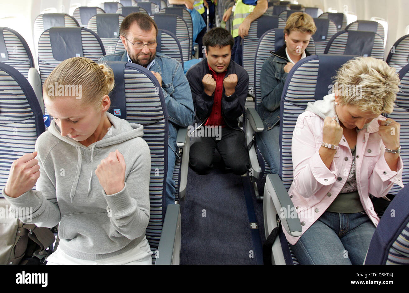 (dpa) - The picture shows German educator Frank Eisenberg (C) during a workshop against fear of flying at the Hanover airport, Hanover, Germany, 06 August 2005. Reasons for the phenomenom are amongst others narrowness and unfamiliar noises on a plane as well as fear of a crash. For some passengers, fear of flying causes serious problems. Panic attacks and anxiety can debar concerne Stock Photo
