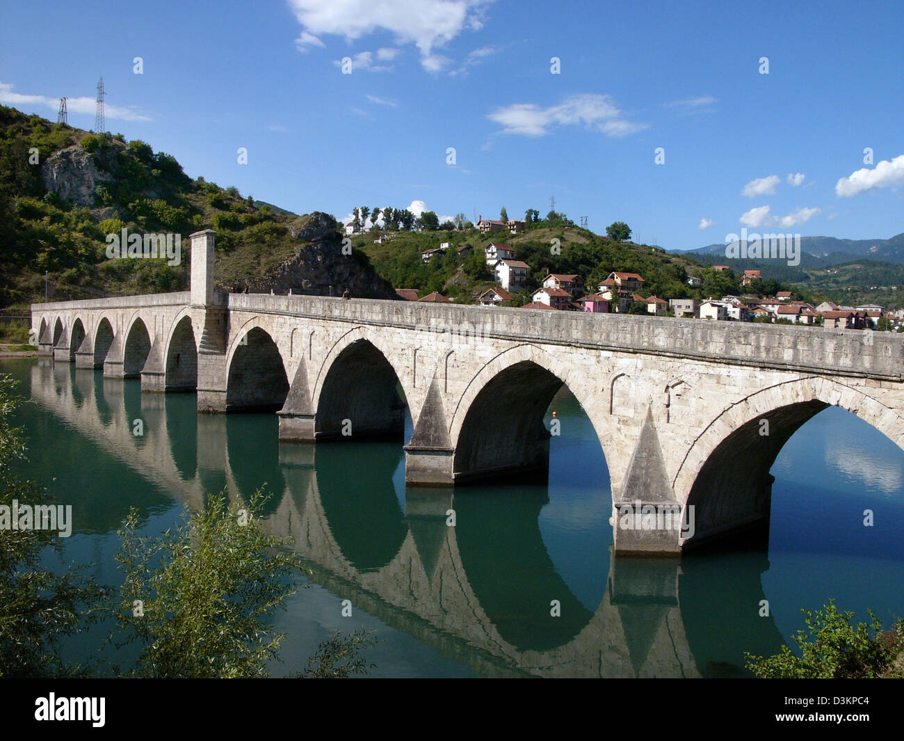 (dpa) - The picture shows a view of Drina bridge with the city of Visegrad in the background, Bosnia and Herzegovina, 2 September 2004. Nobel Prize winner Ivo Andric made the bridge a literatily monument by writing the novel 'The bridge over Drina'. Photo: Matthias Schrader Stock Photo