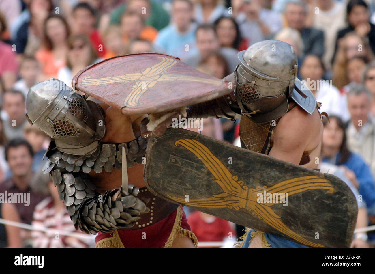 (dpa) - Two actors, dressed as gladiators, stage a fight at the amphitheatre in Trier, Germany, 13 August 2005. At the Roman spectacle 'bread and games' visitors relive what life was like in Roman times. Trier, then named Augusta Treverorum, was founded by the Romans in the year 16 before Christ. 301 years later, Trier became Roman imperial residence. Photo: Harald Tittel Stock Photo