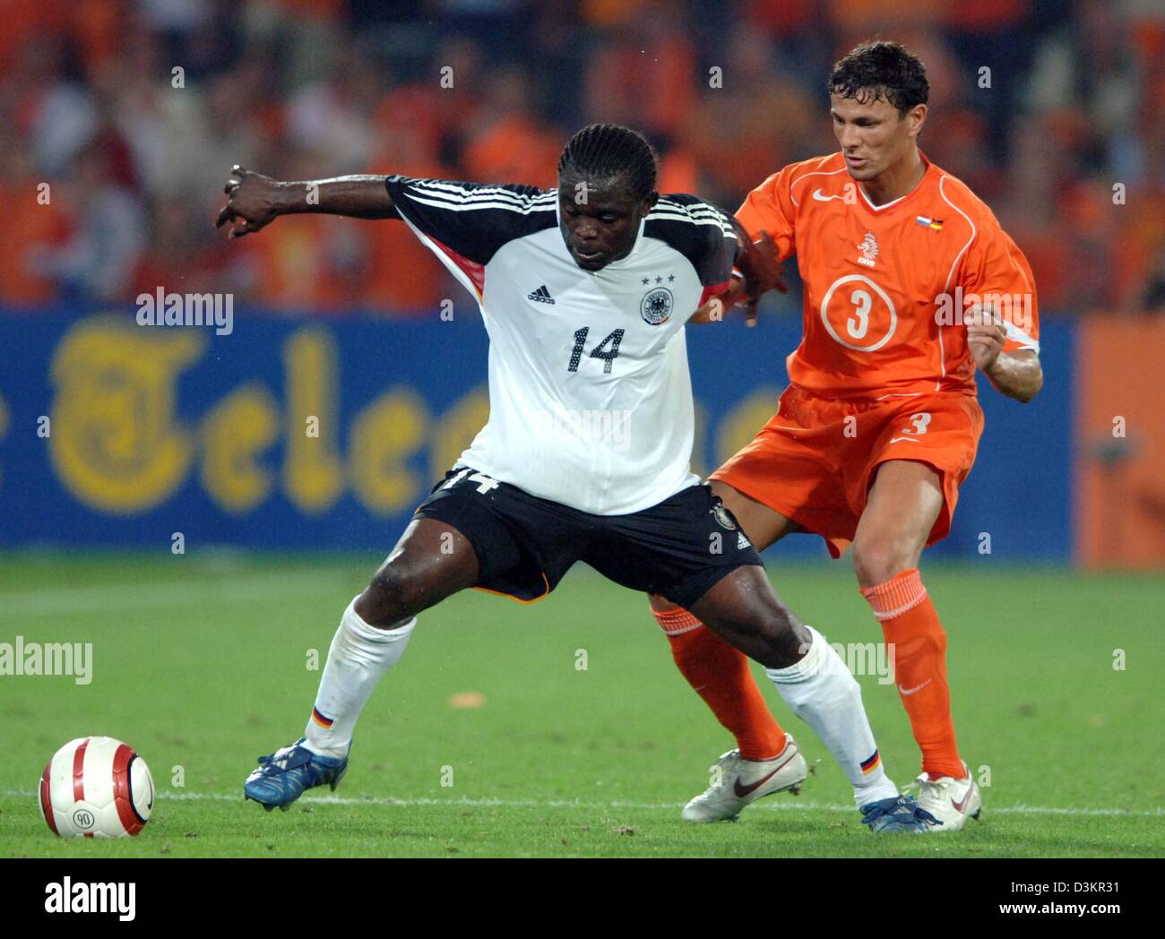 (dpa) - German national soccer player Gerald Asamoah (L) fights for the ball with Dutch national player Khalid Boulahrouz during the friendly match Netherlands vs Germany at the 'De Kuip' stadium in Rotterdam, Netherlands, 17 August 2005. The game ended in a 2-2 draw. Photo: Bernd Weissbrod Stock Photo