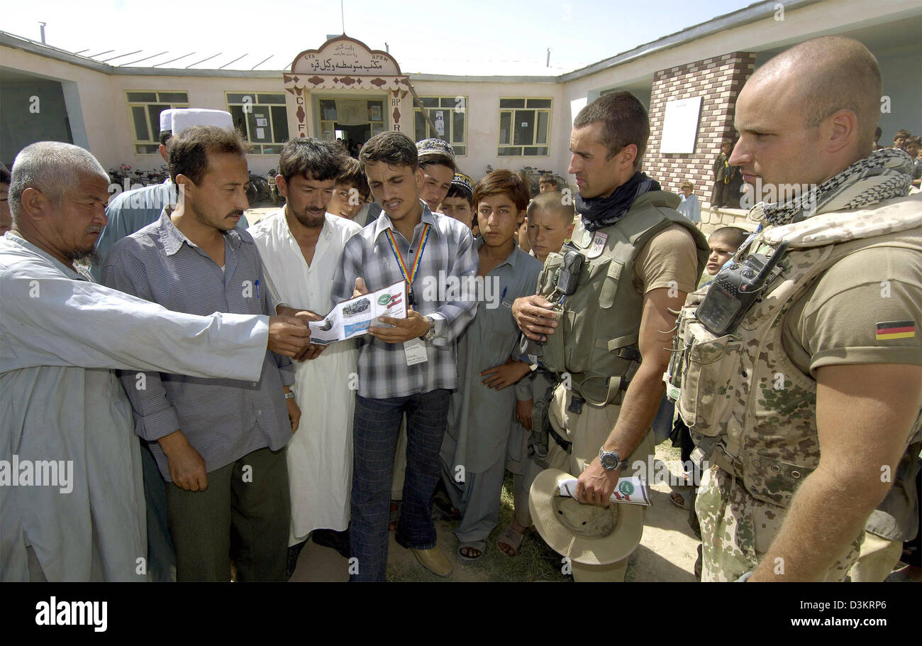 (dpa) -  A soldier of the German Bundeswehr (R) and a soldier of the Austrian army talk to teacher of a rural school 30 kilometres west of the provinical capital of Kundus, Afghanistan, Thursday, 25 August 2005.  As part of the mandate of the International Security Assistance Force (ISAF) for Afghanistan the soldiers examine buildings for their potential use in the elections schedu Stock Photo