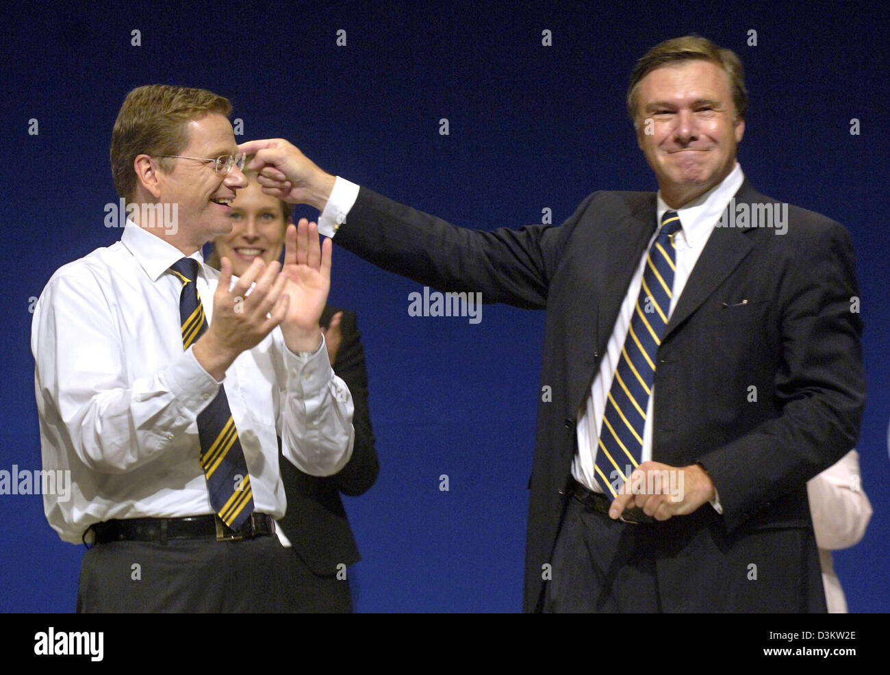 (dpa) - Beside an applauding FDP chairman Guido Westerwelle, the chairman of the Liberal parliamentary fraction Wolfgang Gerhard (R) gesticulating thanks the delegates after his speech at the extraordinary party convention in Berlin, Sunday, 11 September 2005. A week before the Bundestag election the FDP Chairman Westerwelle presented a so called 'competence team' to the delegates Stock Photo