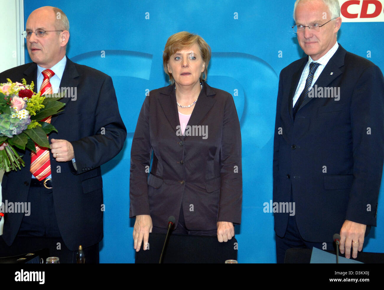 (dpa) - CDU chairwoman Angela Merkel (C) stands between CDU General ...