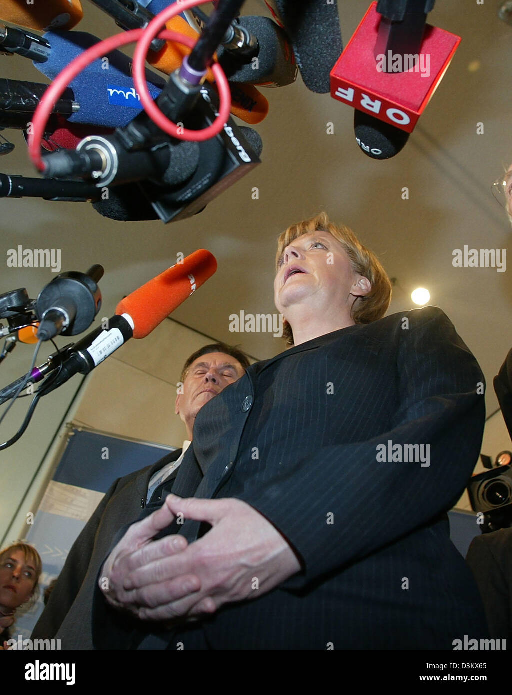 (dpa) - Angela Merkel (front), Chairwoman of the CDU and chancellor candidate, stands next to Michael Glos, Head of the Bavarian CSU, as she speaks during a short press conference after the session of the new elected parliamentary faction of the CDU/CSU in Berlin, Tuesday, 20 September 2005. Despite the week results in the general election for the German Bundestag, Merkel was re-el Stock Photo
