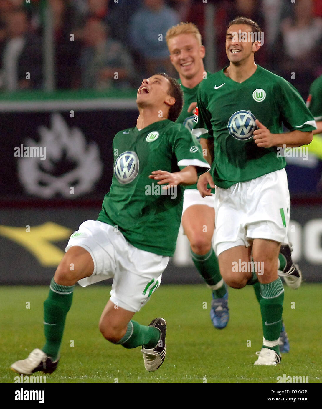 (dpa) - VfL Wolfsburg's Andres D'Alessandro celebrates together with his teammates Mike Hanke and Facundo Quiroga (L-R) his goal against Bundesliga rival Hanover 96 at the AWD-Arena stadium in Hanover, Germany, Tuesday 20 September 2005. Wolfsburg won the match 4-2. Photo: Holger Hollemann Stock Photo