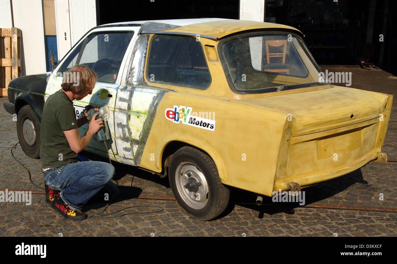 (dpa) - Car mechanic Helge Thomsen polishes his 'Gobbi' in Hamburg, Germany, 22 September 2005. The 'Gobbi' is Thomsen's combined construction of a VW Golf and German Democratic Republic (GDR) product 'Trabant'. To celebrate the 15th anniversary of the German Unity Thomsen also paints the 'Gobbi' in the German national flag colours black, red and gold. Finally the car will be prese Stock Photo