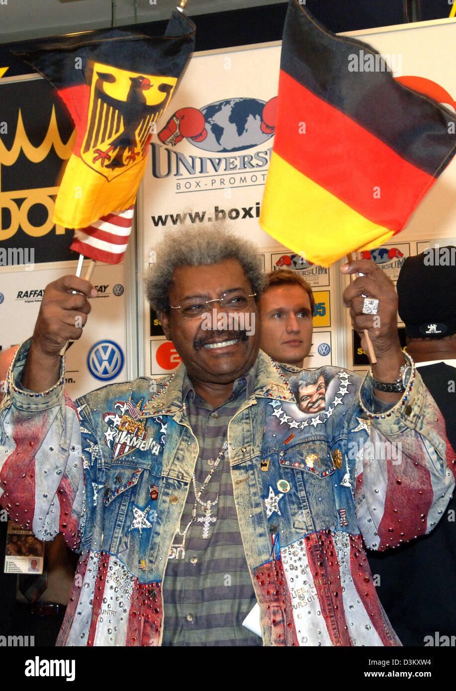 (dpa) - US boxing promoter Don King smiles and waves with the national flags of Germany and the US in Hamburg, Germany, Tuesday, 27 September 2005. In honour of the late German boxing legend Max Schmeling, who would have turned 100 on Wednesday, 28 September 2005, challenger Luan Krasniqi is going to fight US boxing pro and world champion Lamon Brewster for the WBO world champion t Stock Photo