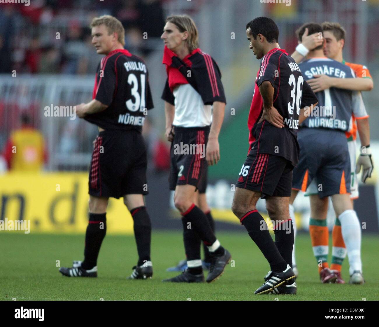 (dpa) - Thoams Paulus, Benjamin Lense and Jaouhar Mnari (L-R, all Nuremberg) walk disappointed over the laen after the Bundesliga match Werder Bremen vs 1.FC Nuremberg in the Weser stadium in Bremen, Germany, Saturday 15 October 2005. Nuremberg lost the match 6-2. Photo: Carmen Jaspersen (Attention: New blocking period! The DFL has prohibited the publication and further utilisation Stock Photo