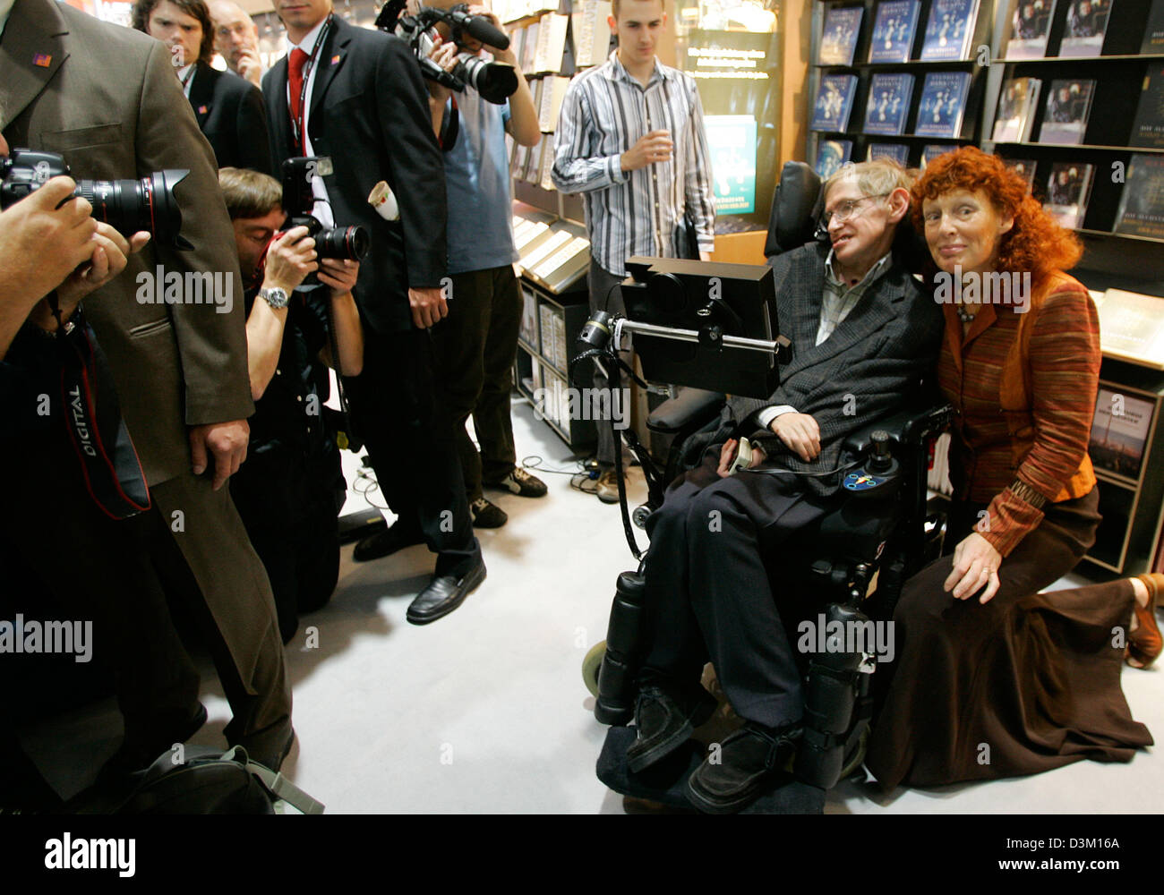 (dpa) - Famous handicapped physicist Stephen Hawking (2nd from R) and his wife Elaine (R) smile on the opening day of the Frankfurt Book Fair 2005 in Frankfurt Main, Germany, Wednesday 19 October 2005. More than 7.000 publishers from all over the world exhibit their latest books as well as classics of literature. The fair's organisers expect several hundred thousand visitors at the Stock Photo