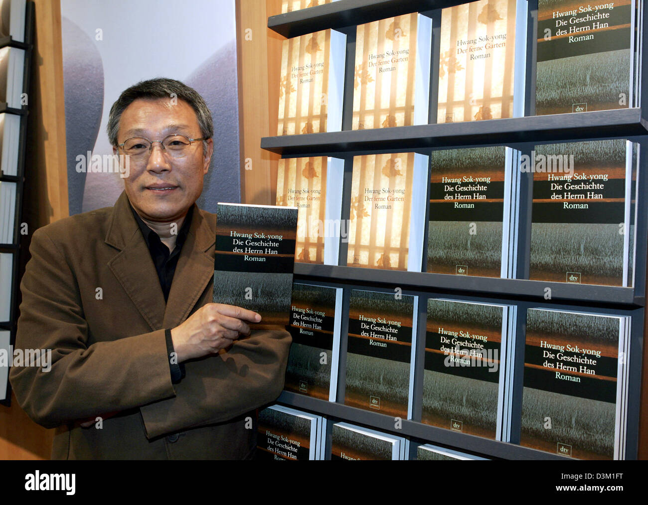 (dpa) - South Korean writer Hwang Sok-yong (62) hlds a copy of his latest novel 'The History of Mr Han' in his hand at the international book fair in Frankfurt, Germany, 19 October 2005. Photo: Jan Woitas Stock Photo